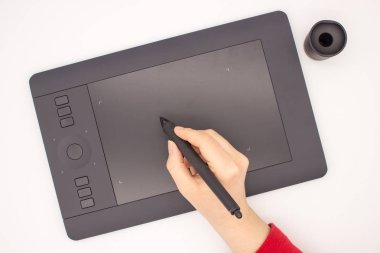 Bir kadın eli kırmızı bir kol bir grafik tablet kalem çizer. Beyaz bir arka planda izole görüntüdür.