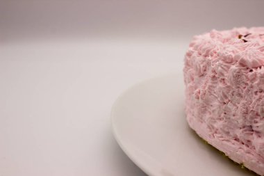 Beyaz-gri arka plan üzerinde bir plaka üzerinde pembe bir kek parçası. Resim kopyalama alanı alanı ile.