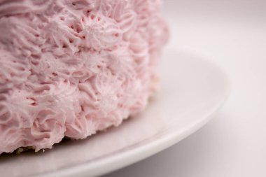 Beyaz-gri arka plan üzerinde bir plaka üzerinde pembe bir kek parçası. Resim kopyalama alanı alanı ile.