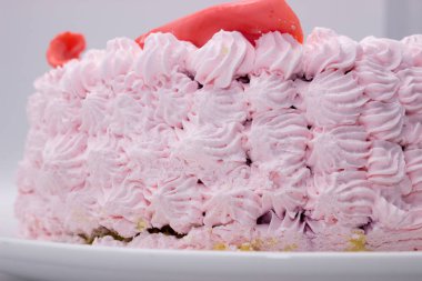 Bir krem bir plaka üzerinde pembe kek dekore edilmiştir.
