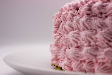 Beyaz-gri arka plan üzerinde bir plaka üzerinde pembe bir kek parçası. Resim kopyalama alanı alanı ile.