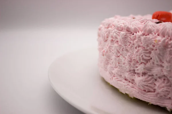 ホワイト グレーの背景に皿の上のクリーム ピンクのケーキの作品 コピー領域の画像 — ストック写真