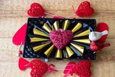 Lezzetli çikolatalı pralin yürekleri eski ahşap zemin üzerine altın folyo sarılmış