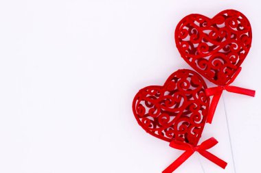 Bir beyaz duvar arka plan kırmızı süslü ajur kalpler. Sevgililer günü kavramı.