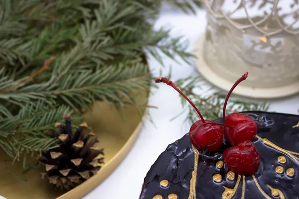 Delicious chocolate cake, decorated cherries, and sugar Santa an — Stock Photo, Image