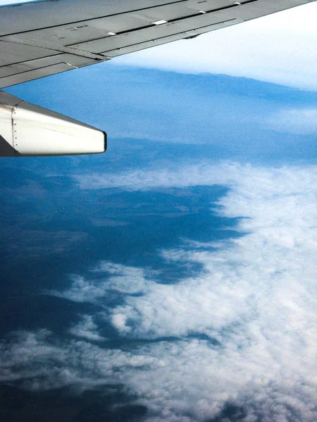 Vista desde el ojo de buey del avión sobre nubes blancas. El marco también —  Fotos de Stock