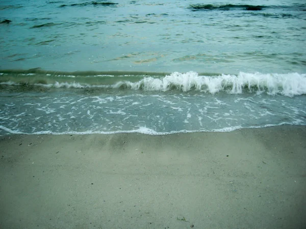 Le morbide onde del mare rotolano dolcemente sulla spiaggia sabbiosa. Bella foto — Foto Stock