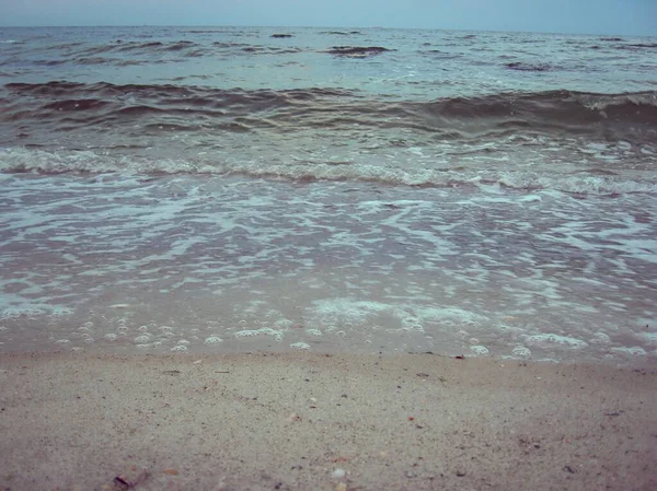 As ondas suaves do mar rolam suavemente na praia de areia. Foto bonita — Fotografia de Stock