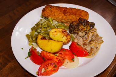 Basit Bulaşıkların Lezzetli Yemeği. Pirzola, mantar, fırında patates ve dilimlenmiş domates..