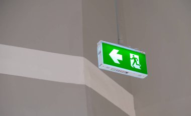 Yangın çıkış ışık işareti. Kaçmak için yol gösteren yeşil acil çıkış işareti.