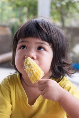 Asyalı kız rustik tarzı olgun Mısır tutun. Vejetaryen ürün.