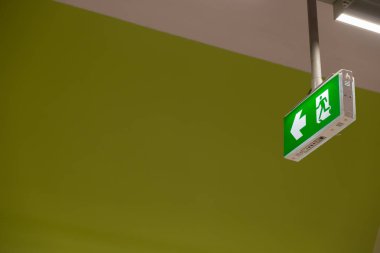 Yangın çıkış ışık işareti. Kaçmak için yol gösteren yeşil acil çıkış işareti