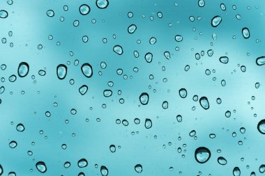 Mavi arka plan, cam üzerine doğal su damlası.