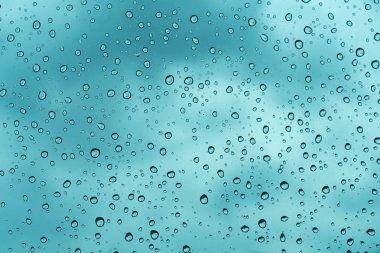 Mavi arka plan, cam üzerine doğal su damlası.