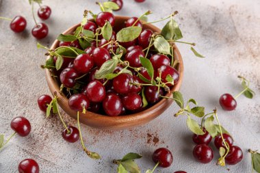 Taş arka plan üzerinde yaprakları ile taze tatlı kiraz kase, üst görünümü