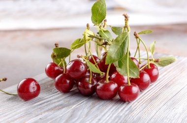 Taş arka plan üzerinde yaprakları ile taze tatlı kiraz kase, üst görünümü