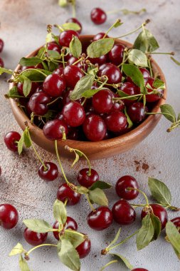 Taş arka plan üzerinde yaprakları ile taze tatlı kiraz kase, üst görünümü