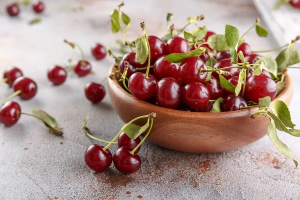 Taş arka plan üzerinde yaprakları ile taze tatlı kiraz kase, üst görünümü