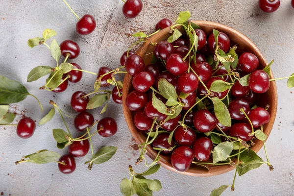 Taş arka plan üzerinde yaprakları ile taze tatlı kiraz kase, üst görünümü