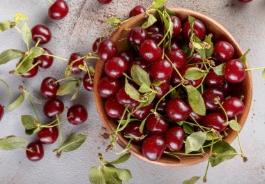 Taş arka plan üzerinde yaprakları ile taze tatlı kiraz kase, üst görünümü