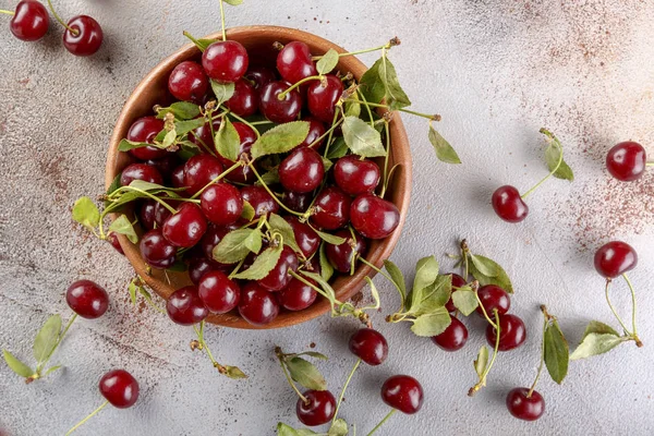 Taş arka plan üzerinde yaprakları ile taze tatlı kiraz kase, üst görünümü