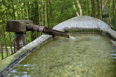 Tsukubai, bir tekne şeklinde taş su havzası ile akan bir su borusuna ile su içine bir rock tekne içinde Japon çay bahçesi içinde Golden Gate Park, San Franciso, Ca.