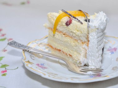 Tropik meyve ve altın eşiğinde ile geniş porselen tabakta krema ile sünger kek