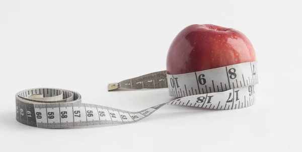 diyet kavramı ile elma ve beyaz arka plan üzerinde izole ölçüm bandı