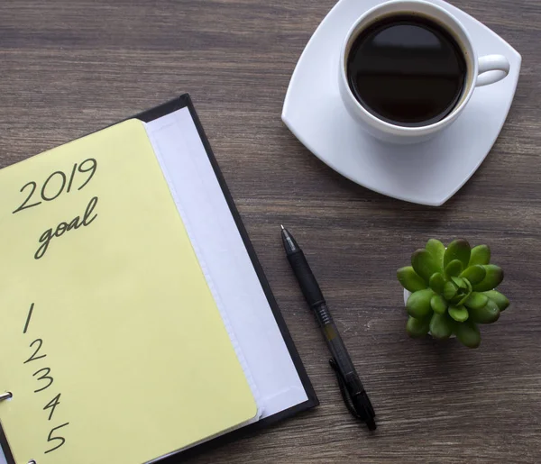 Yeni yıl kavramı - 2019 sayı ve metin üzerinde not defteri. Kalem ve fincan kahve arka plan.