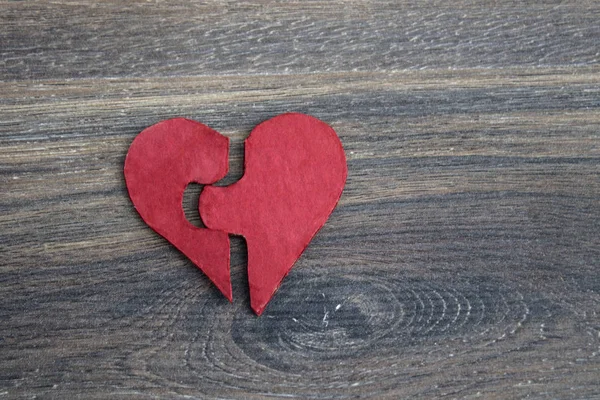 gri ahşap arka plan üzerinde kırmızı puzzle kalp