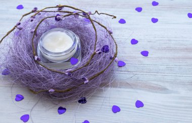 Nemlendirici bakım mor sisal Beyaz ahşap zemin üzerinde yatan kavanoz açın. çevresinde birçok kupa