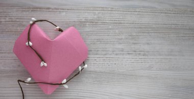 Kağıt pembe kalp bir beyaz tahta backgraund karşı. Uzay kopyalayın. Boş alan için metin, yakın çekim, üstten görünüm
