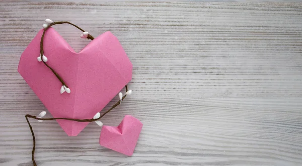 Kağıt pembe kalp beyaz boyalı yüzeye karşı. Uzay kopyalayın. Boş alan için metin, yakın çekim, üstten görünüm