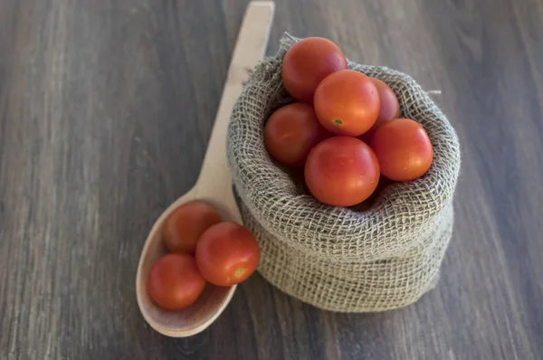 Beyaz arka plan ve tahta kaşık izole tuval çanta içinde domates