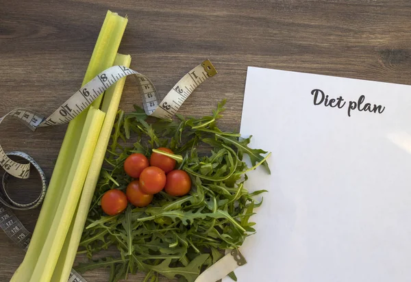 Diyet planı, menü veya program, ölçme bant ve diyet gıda taze roka ve domates koyu ahşap arka plan, kilo kaybı ve detoks kavramı, üstten görünüm