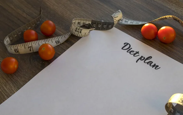 Diyet planı, menü veya program, ölçme bant ve diyet gıda taze roka ve domates koyu ahşap arka plan, kilo kaybı ve detoks kavramı, üstten görünüm