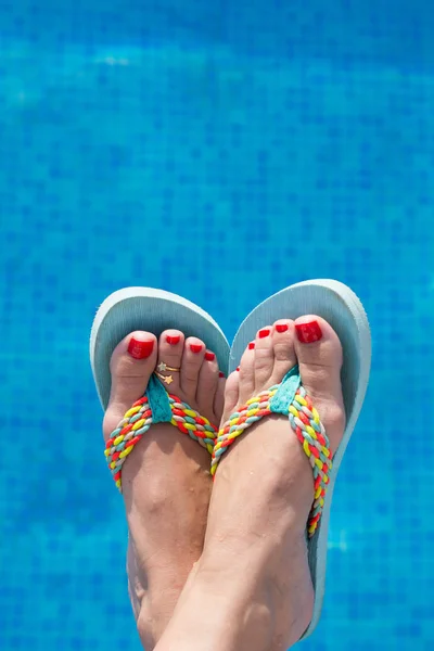 Havuzun hemen kenarında renkli sandalet ile Ayaklar