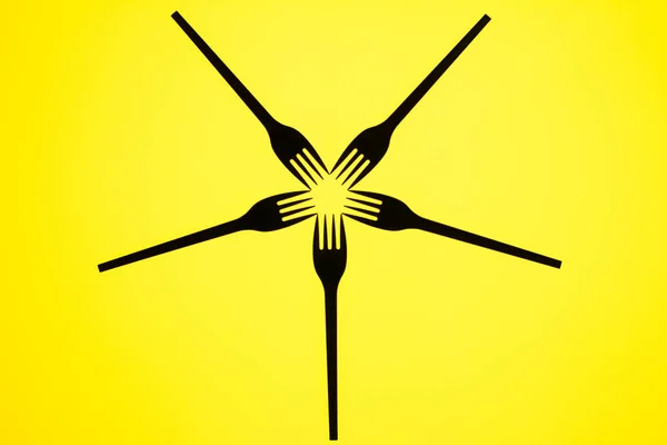 Beş siyah çatal ve sarı arka plandan oluşan yüksek kontrastın natürmort görünümü