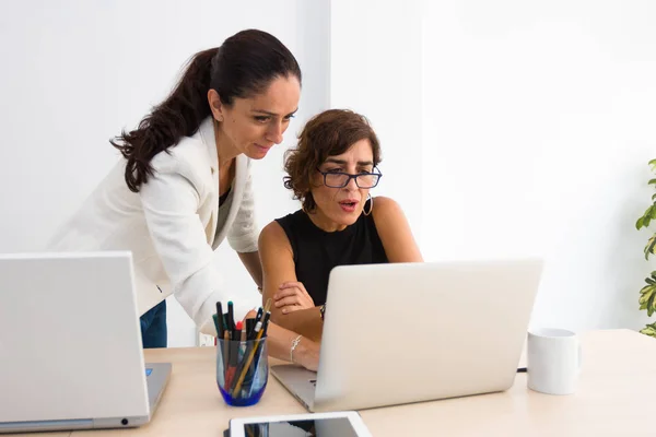 Duas mulheres falam sobre o que vêem na tela de um laptop — Fotografia de Stock