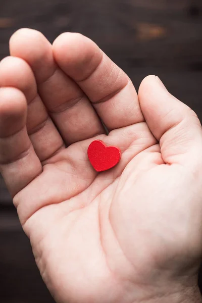 Hand protecting a small heart located on the line called 