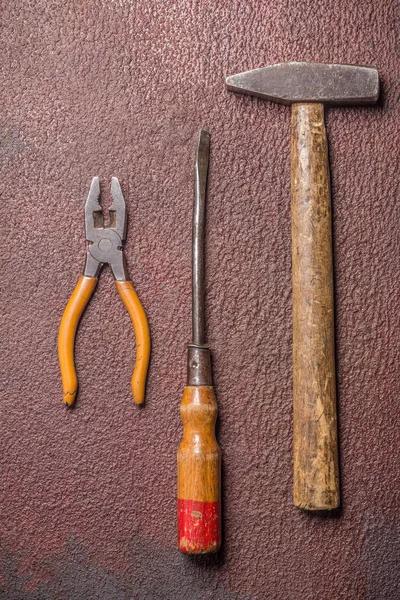 Destornillador, alicates y martillo sobre placa de acero oxidada — Foto de Stock