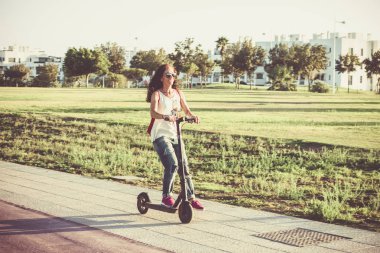 Scooter'ı ile durdurmak için ayağını yere atan kadın