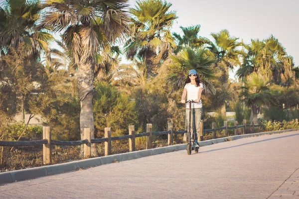 Parkta elektrikli tekme scooter sürme Kadın