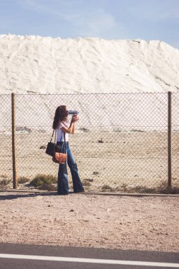 Film yapımcısı tel örgülerin arkasından çekim yapıyor.