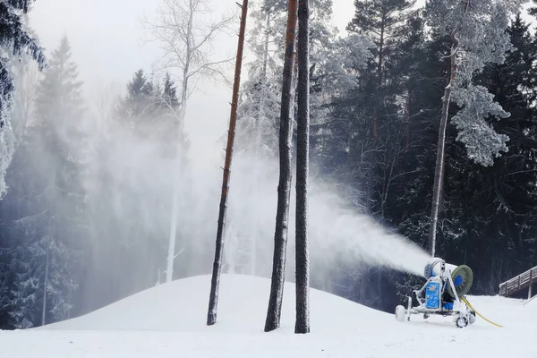 Professional snow machine that makes snow out of the water. Beautiful forest landscape