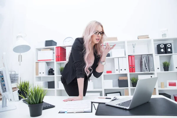 Girl in the workplace records a voice message