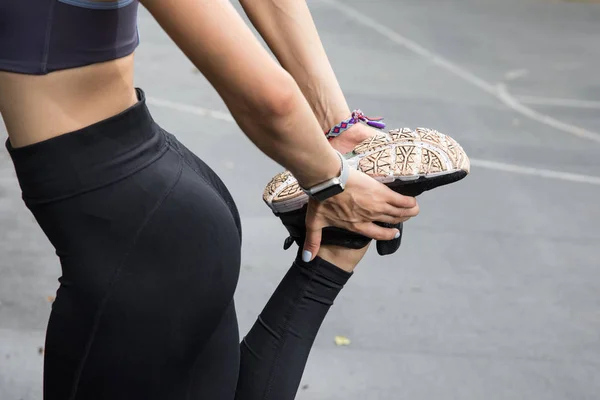 运动上衣的健身模型和在公园训练前伸展的腿 完美的女性健身身材 — 图库照片