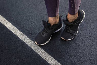 Atlet siyah spor ayakkabı beyaz start çizgisinde önünde duruyor