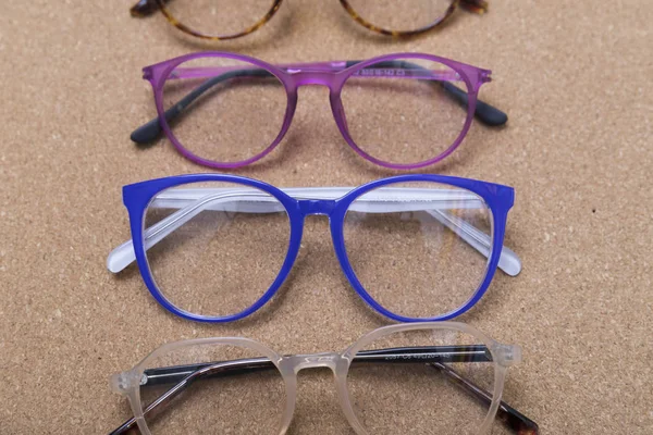 Different eyeglass frames on cork board