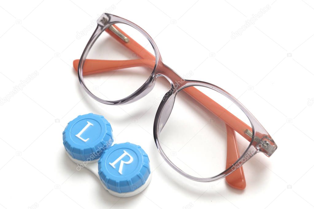 Eyeglass frames and a container with contact lenses. Isolated